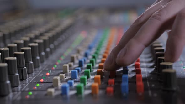 Record Producer Adjusting Sound on Audio Console