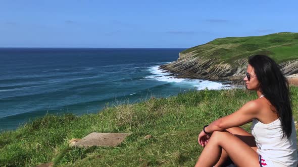 Woman enjoying a sunny day on the coast and nice views of the sea and the beach