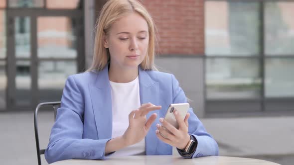 Young Businesswoman Excited for Success on Smartphone