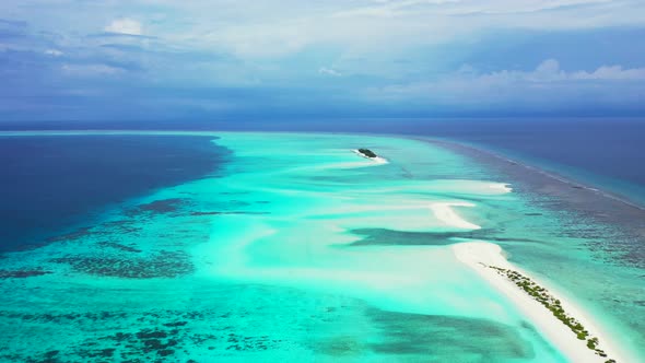 Wide angle flying travel shot of a white sandy paradise beach and turquoise sea background in 4K