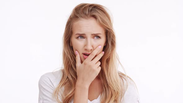 Young Beautiful Caucasian Blonde Girl Scared Worried Concerned Holding Hand Near Mouth on White