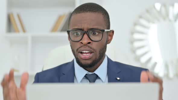 Portrait of African Businessman Reacting to Loss on Laptop