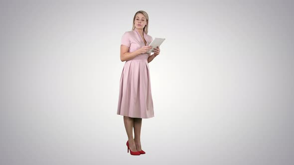 Female young woman in pink standing with tablet and giving