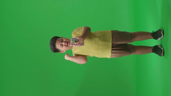 Full Body Of Asian Little Boy Surprise And Celebrating During Use Mobile Phone On Green Screen