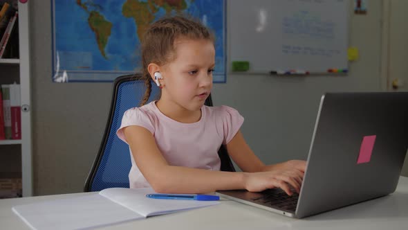 Cute Primary School Girl Studying with Laptop at Home Doing Homework