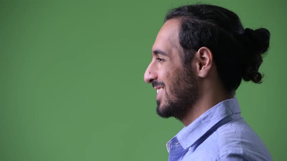 Profile View of Young Happy Bearded Indian Businessman Smiling
