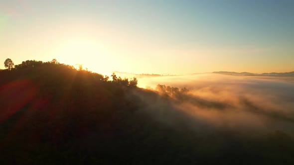 4K Aerial view from drone over mountains and sea of fog. Golden scenery at sunrise