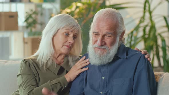 Depressed Elderly Couple Sitting on The Couch in the Living Room at Home