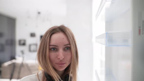 Woman Opens Door of an Empty Fridge Surprised View From Inside