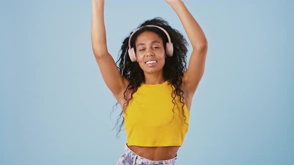 Afroamerican Female in Casual Clothes is Smiling and Dancing Listening to the Music Through