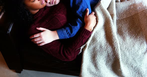 Lesbian couple sleeping together on couch