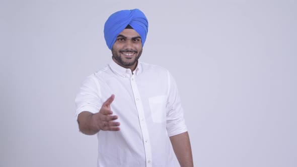 Happy Young Bearded Indian Sikh Man Giving Handshake