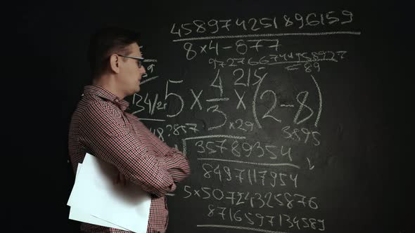 Man Writes Math Formula on Blackboard