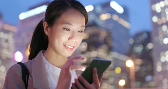 Business woman use of mobile phone in city at night