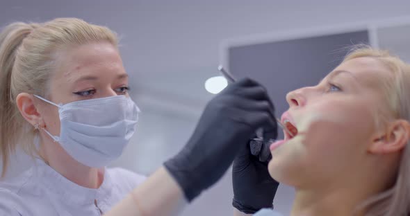 Young Woman Dentist Examines the Teeth of a Girl Patient a Professional Examination of the Oral