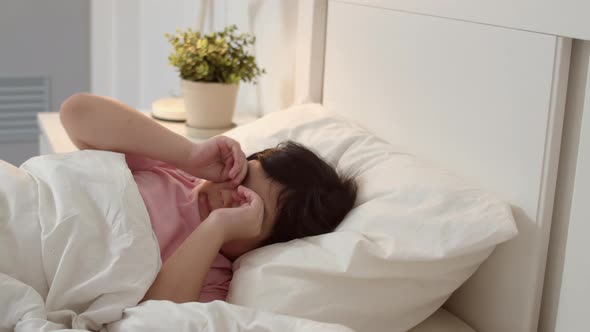 Young Asian girl wake up at home. Asia japanese woman child kid relax rest after sleep all night.