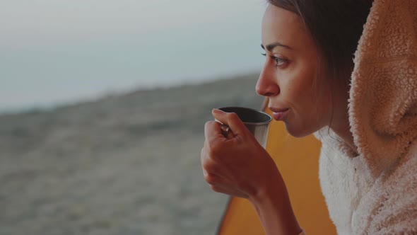 Closeup Portrait of Confident Pretty Woman Sitting at Tent Entry and Holding Mug with Coffee in Hand