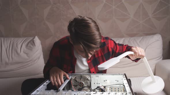 Front View of a Caucasian Schoolboy Working on a Computer Device.