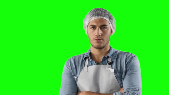 Caucasian man with an apron on a green background
