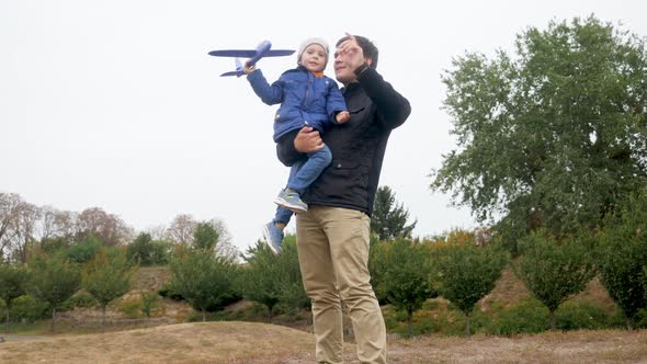 Video of Happy Smiling Little Boy Launching Toy Airplane High in the Air While Playing on Meadow at