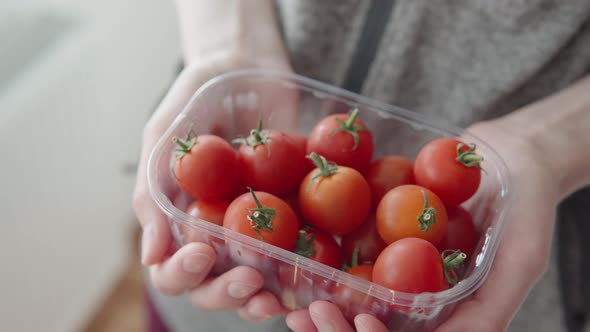 Woman Shows Ripe Red Cherry Tomatoes Grown on a Plantation for Sale Closeup in Box