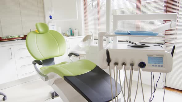 Empty interior of dental clinic with green dental chair and tools