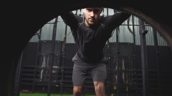 Fit Caucasian Male Athlete Doing Tireflip Exercise Indoors