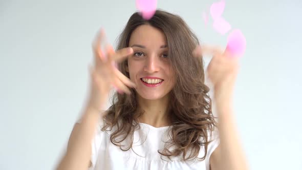 Beautiful Brunette in White Dress with Pink Confetti in Heart Shape