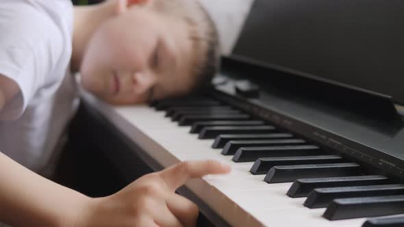 Electronic Piano. Fingers Press the Piano Keys. Music Lesson. Child Was Tired in the Lesson and Lay