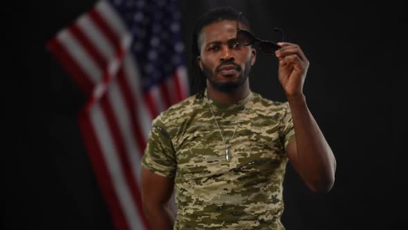 Portrait of Confident African American Military Man in Khaki Tshirt Taking Off Sunglasses Crossing