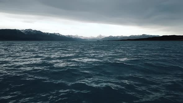 Aerial drone shot flying low over Lake Pukaki in New Zealand.