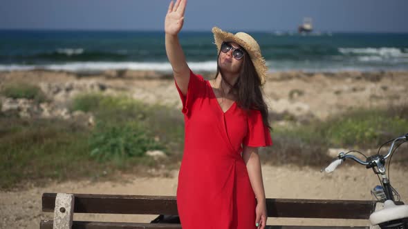 Young Beautiful Woman Looking Up at Sunshine Standing on Mediterranean Sea Beach on Cyprus