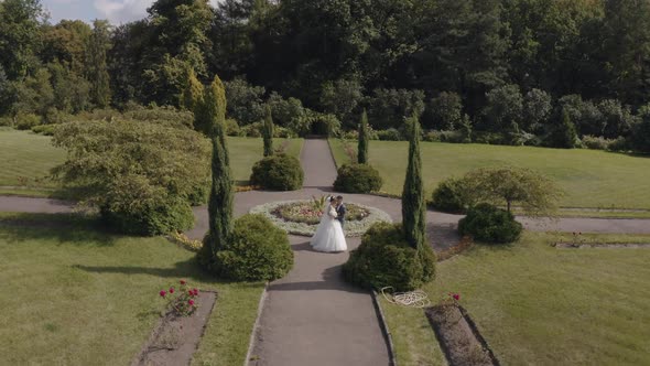 Newlyweds, Caucasian groom with bride walking, embracing, hugs in park, Wedding couple