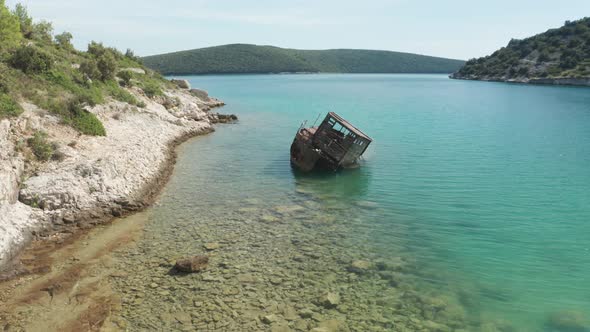 Close up shot of a rusted ship wreck stranded at Luca beach, Croatia. Aerial shot, camera flies over