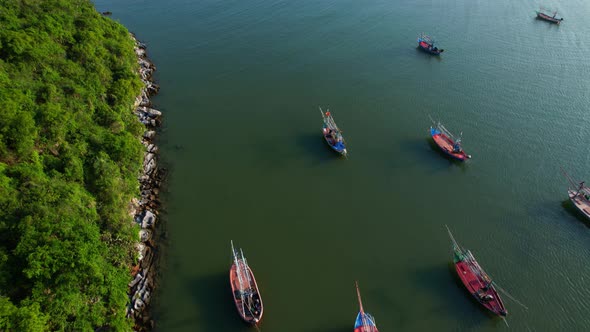 Many fishing boats on the coast beside the mountains, beautiful sea area in Thailand.