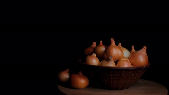 Pile of Whole Bulbs of Raw Onion in Ceramic Bowl on Table