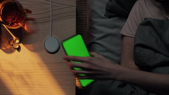 Woman Putting Mobile with Green Screen to Charge at Night