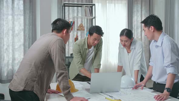 Group Of Asian Engineers Using A Laptop For Working At The Office