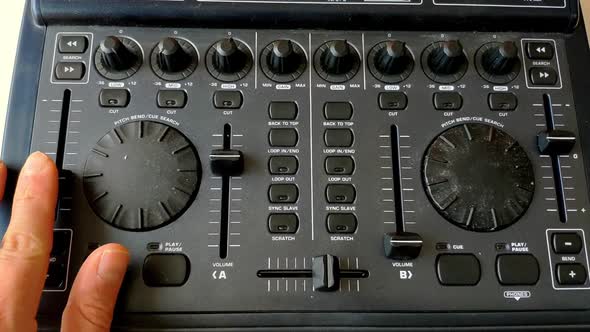 A DJ interface for dj'ing from computer is seen. A fader is raised and de deck is turned forward to