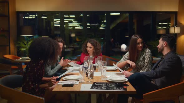 Diverse Group Sitting Restaurant Table at Night