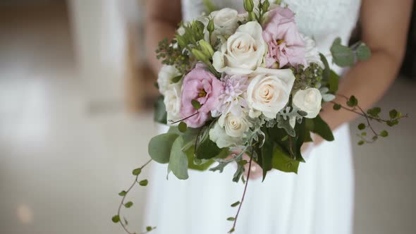 Bride Holding Flowers in Hands Before Wedding Ceremony