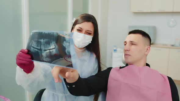 The Dentist Together with the Patient Examine the Computed Tomography of the Dental Jaw