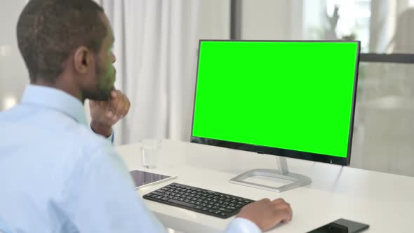 Pensive Businessman Working on Desktop with Green Chroma Key Screen