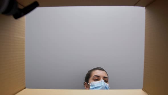 Woman in Mask Packing Parcel Box with Cosmetics