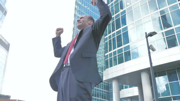 Middle Aged Businessman Celebrating Success Outside Office
