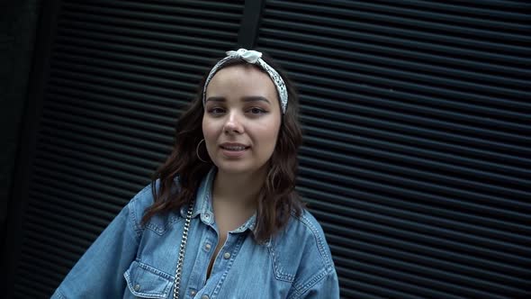 Close-up Portrait of a Young Dark-haired Woman in Jeans and with a Bandage on Her Head, She Is on