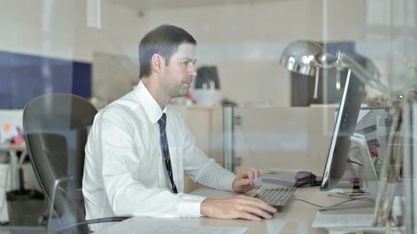 Middle Aged Businessman Working on Office Computer