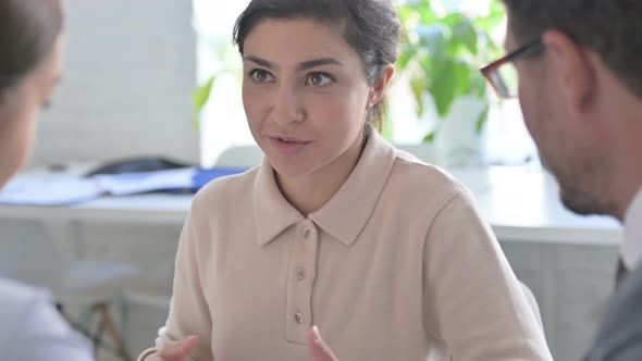 Serious Indian Businesswoman Having Discussion with Colleagues