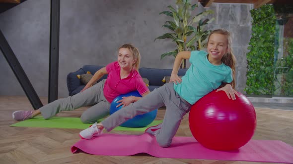Fit Female and Child Exercising with Fitness Ball