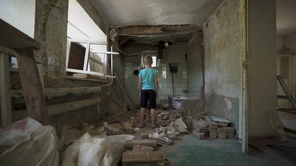 Ukrainian boy in a destroyed house. a homeless child in dirty clothes. war Ukraine